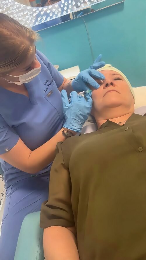 Practitioner in scrubs and gloves treating the under eye area of a client lying on a couch during a Lumi Eyes polynucleotide treatment at Skintastic in Southampton